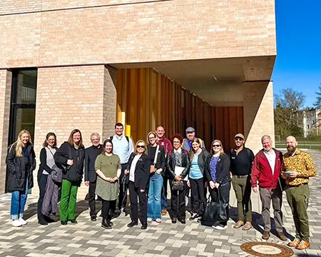 Delegation aus Amerika mit Gastgebern vor dem Schulgebäude